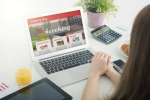 Woman looking at a culinary blog on a laptop